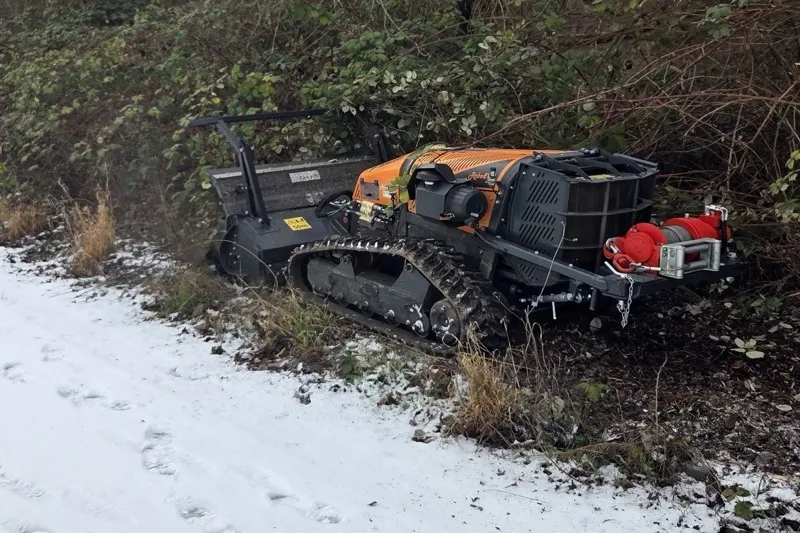 Raupenmulcher bei Komplettrodung eines verwilderten Grundstücks im Winter